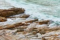 Turquoise rolling wave slamming on the rocks of the coastline