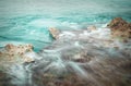 Turquoise sea with rocks and hazy waters, long exposure