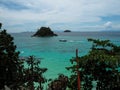 Turquoise sea view with long-tail boat, small island and blue sk Royalty Free Stock Photo