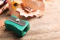 Turquoise sharpener and pencil shavings on wooden table, closeup. Space for text Royalty Free Stock Photo