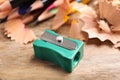 Turquoise sharpener, pencils and shavings on wooden table, closeup