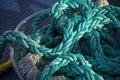 Turquoise ship ropes and rigging in a metal basket on a boat