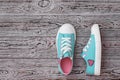 Turquoise sneakers with embroidered heart on the wooden floor. Sports style. Flat lay. Royalty Free Stock Photo