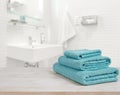 Turquoise spa towels pile on wood over blurred bathroom background Royalty Free Stock Photo