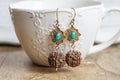 turquoise stone Indian seed earrings on white cup background