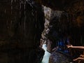 People's hands reach for dripping drops of icy water flowing down from the rocks. Royalty Free Stock Photo