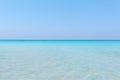 Turquoise tranquil ocean merging with clear beautiful sky at horizon line on sunny warm day