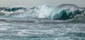 Turquoise tunnel wave strike against shallow water.