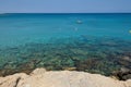 Turquoise water of Mediterranean sea with stones, boats and coast