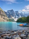 Turquoise waters of beautiful Moraine lake. Snow-covered Rocky mountains in summer day. Canoes on a jetty. Royalty Free Stock Photo