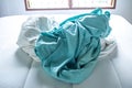 Turquoise and White crumpled bed sheet on white bed, Selective focus, Bedroom cleaning concept Royalty Free Stock Photo