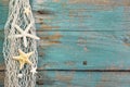 Turquoise wooden background with starfish - maritime decoration.