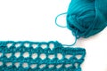 Turquoise yarn skein wound and crochet sample with white copy space background