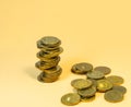 Turret made of coins. Scattering of coins on a beige background Royalty Free Stock Photo