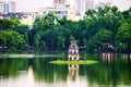 Turtle Tower at Hoan Kiem Lake in Hanoi, Vietnam. Tree at the foreground Royalty Free Stock Photo