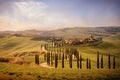 Tuscan hill with row of cypress trees and farmhouses  at sunset. Tuscan landscape. Italy Royalty Free Stock Photo