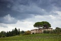 Tuscan hillside panorama with cloudy sky and typical local habit