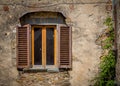 Tuscan window with brown shutters and green vines Royalty Free Stock Photo