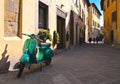 TUSCANY, AREZZO 25.04.2019. Vintage green Vespa Piaggio scooter in old narrow street in historical center of Arezzo with facade of