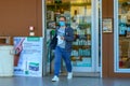 White man with glasses and face mask exit a pharmacy. Guy near a shop, walking with a bag in hand during pandemic Royalty Free Stock Photo