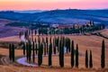 Tuscany landscape with grain fields, cypress trees on the hills at sunset in Tuscany, Italy, Europe Royalty Free Stock Photo