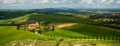 Tuscany landscape with green rolling hills in spring time ,agriculture crop and farming house