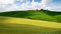 Tuscany landscape, small house on top of a hill against blue sky