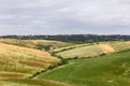 Tuscany rolling hills with cultivated meadows in the evening with heavy clouds