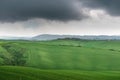 Tuscany, rural landscape. Countryside farm, cypresses trees, green field, cloudy day Royalty Free Stock Photo