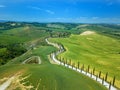 Tuscany rural sunset landscape. Countryside farm, cypresses trees, green field, sun light and cloud. Italy Royalty Free Stock Photo