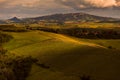 Tuscany, sunset landscape panorama of the city of Volterra with hills, vineyards and classic dirt road in foreground