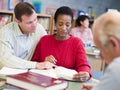 Tutor assisting mature student in library