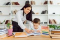 Tutor deals with the preschooler with a laptop, a real home interior, the concept of childhood and learning