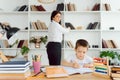 Tutor deals with the preschooler with a laptop, a real home interior, the concept of childhood and learning