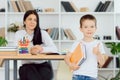 Tutor deals with the preschooler with a laptop, a real home interior, the concept of childhood and learning