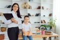 Tutor deals with the preschooler with a laptop, a real home interior, the concept of childhood and learning