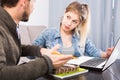 Tutor explaining material to his female client at home