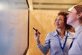 Tutor With Female Trainee Electrician Looking At Wiring Diagram On Screen Royalty Free Stock Photo