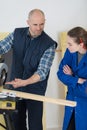 Tutor showing circular saw to student