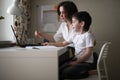 Tutor teach preschooler with laptop, real home