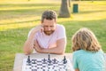 tutorship. dad and kid play logic game. father and son playing chess at table