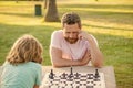 tutorship. dad and kid play logic game. father and son playing chess at table