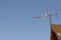 TV analog antenna on the roof of the house, against the blue sky