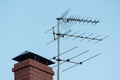 TV antenna on red roof. television antenna on roof with blue sky. Brick pipe house and media transmitter, radio