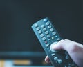 Male hand is holding TV remote control, streaming on a smart TV Royalty Free Stock Photo