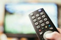 Male hand is holding TV remote control, streaming on a smart TV Royalty Free Stock Photo