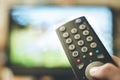 Male hand is holding TV remote control, streaming on a smart TV Royalty Free Stock Photo