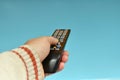 Tv remote control in the hand of a man on a blue background Royalty Free Stock Photo