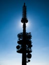 TV transmitte tower silhouette with sun hidden behind and blue sky background