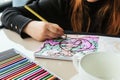 TVER, RUSSIA - FEBRUARY 11, 2023: a young woman draws neurography at a table at a psychological session, a neurographic